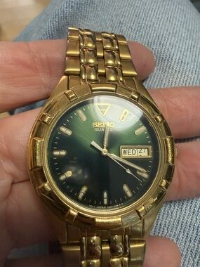 Vintage Seiko gold quartz watch with emerald green face and date